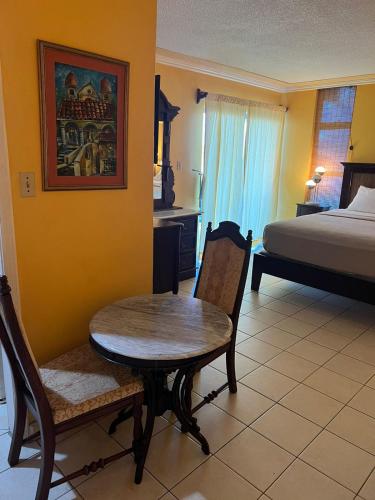 una camera con letto, tavolo e sedie di Sunny Tides at Montego Bay Club Resort a Montego Bay