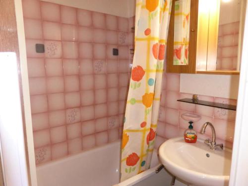 une salle de bain avec un lavabo et un rideau de douche dans l'établissement Résidence Combettes - Combettes D292 MAE-5624, aux Contamines-Montjoie