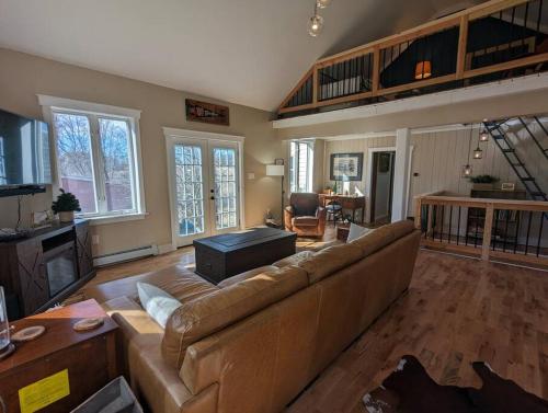 ein großes Wohnzimmer mit einem Sofa und einem Tisch in der Unterkunft Newmont Lodge in Hoosick Falls
