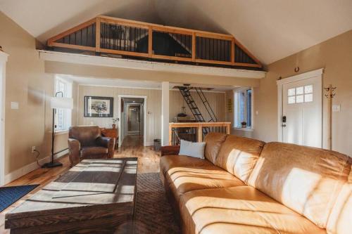 ein Wohnzimmer mit einem Sofa und einem Loft in der Unterkunft Newmont Lodge in Hoosick Falls