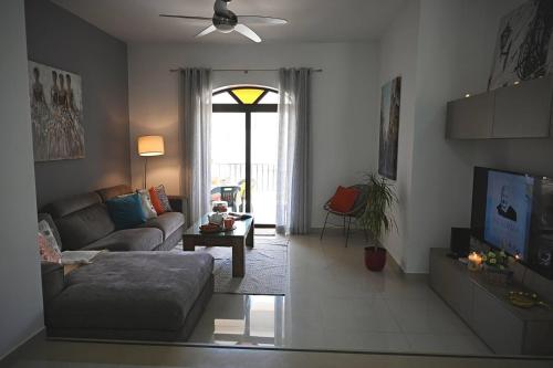 a living room with a couch and a tv at Fl 2 Ta'lonza Luxury With Hot Tub By Homely in Mellieħa