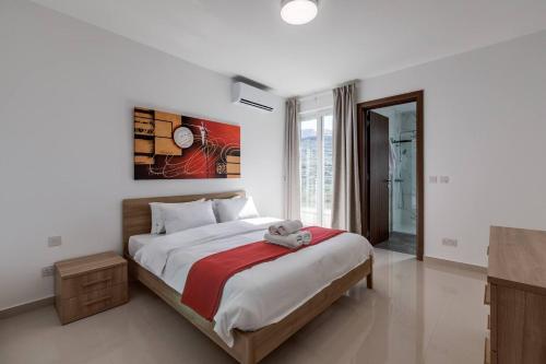 a bedroom with a large bed and a television at 9ten11 Seafront in Mellieħa