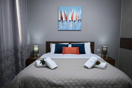 a bedroom with a large bed with red and blue pillows at Fl 2 Ta'lonza Luxury With Hot Tub By Homely in Mellieħa