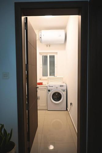 a laundry room with a washing machine and a window at Fl 2 Ta'lonza Luxury With Hot Tub By Homely in Mellieħa