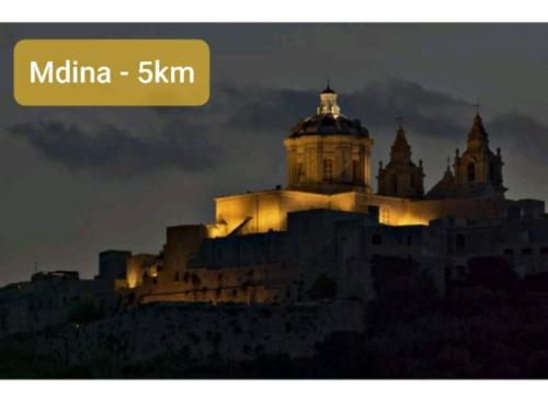 a building on top of a hill at night at Fl 2 Ta'lonza Luxury With Hot Tub By Homely in Mellieħa