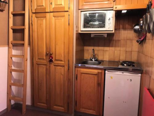 une petite cuisine avec un évier et un micro-ondes dans l'établissement Résidence Les Cristaux Du Bas - Cristaux 44 MAE-1984, à Combloux