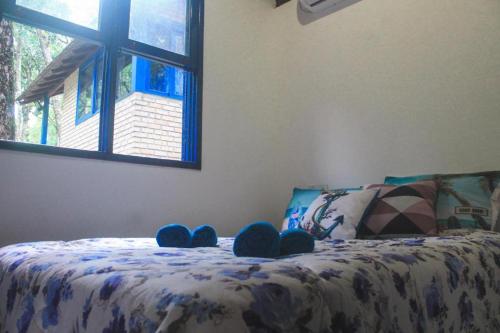 a bedroom with a bed with blue shoes on it at Villa Cabanas - Pé na areia in Governador Celso Ramos