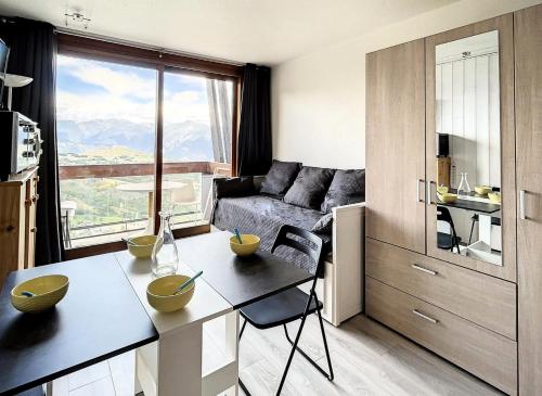 - un salon avec un canapé et une table avec des bols dans l'établissement Résidence Vanguard - Studio rénové · Pied des pistes · Balcon · WIFI gratuit MAE-9614, au Corbier