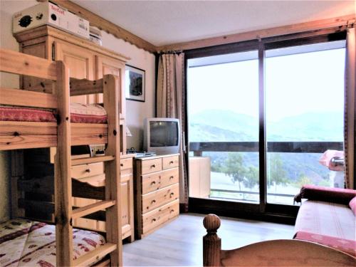 a bedroom with a bunk bed and a desk with a television at Résidence Phenix - RESIDENCE PHENIX STUDIO POUR 4 PERSONNES MAE-9884 in Le Corbier