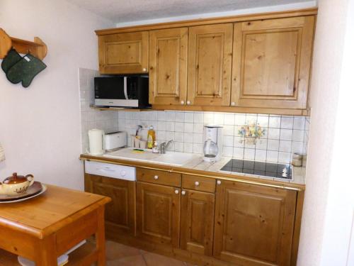 une cuisine avec des armoires en bois et un comptoir dans l'établissement Résidence Les Carlines - Carlines 3 MAE-8424, aux Contamines-Montjoie