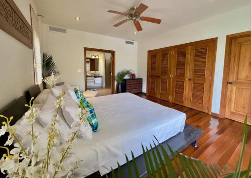 a bedroom with a white bed and a ceiling fan at Stunning 1 Bedroom Hideaway Palm / Garden View in Gaynors