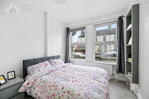 um quarto com uma cama e uma janela em Cosy Tottenham Apartment Sleeps 4 em Londres
