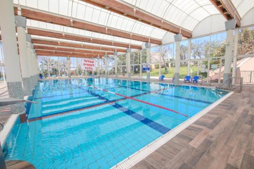 uma grande piscina com água azul em מול הים בקיסריה em Caesarea