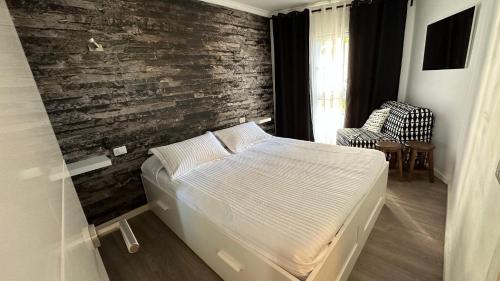 een slaapkamer met een bed en een bakstenen muur bij Torres Yomely Las Americas in Playa de las Americas