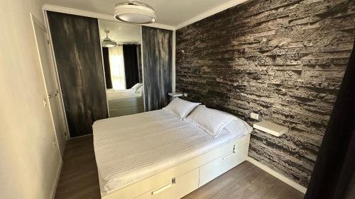een slaapkamer met een bed en een bakstenen muur bij Torres Yomely Las Americas in Playa de las Americas