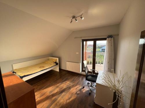 1 dormitorio con cama, escritorio y ventana en Dom Krotoszyce, en Krotoszyce