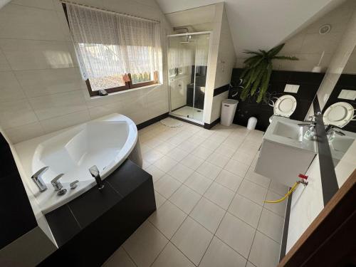 un ampio bagno con vasca e lavandino di Wyłączony a Krotoszyce