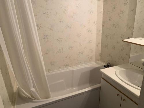 een badkamer met een wit bad en een wastafel bij Résidence Royal Peyragudes Mp - Studio pour 4 Personnes 714 in Germ