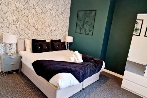 a bedroom with a bed and a green wall at Fantastic Home! Football Fans -5 min to Stadium in Liverpool