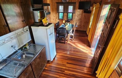 a kitchen and dining room with a table and a refrigerator at La Floresta - Cabañas con Naturaleza y Tranquilidad in Puerto Iguazú
