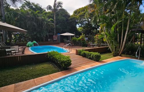 a swimming pool in a backyard with a wooden deck at La Floresta - Cabañas con Naturaleza y Tranquilidad in Puerto Iguazú