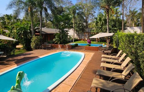 a swimming pool with chaise lounge chairs next to a resort at La Floresta - Cabañas con Naturaleza y Tranquilidad in Puerto Iguazú
