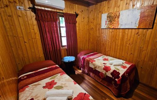 a bedroom with two beds and a window in it at La Floresta - Cabañas con Naturaleza y Tranquilidad in Puerto Iguazú