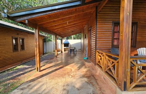 a porch of a wooden cabin with a roof at La Floresta - Cabañas con Naturaleza y Tranquilidad in Puerto Iguazú