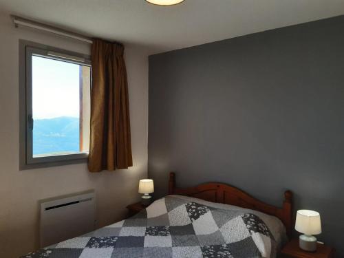 um quarto com uma cama com um cobertor xadrez e uma janela em Résidence Hameau De Balestas Mp - 2 Pièces pour 6 Personnes 684 em Germ