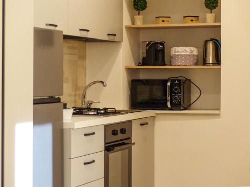 a small kitchen with a sink and a microwave at Struttura Monte Olimpo in Porto Torres