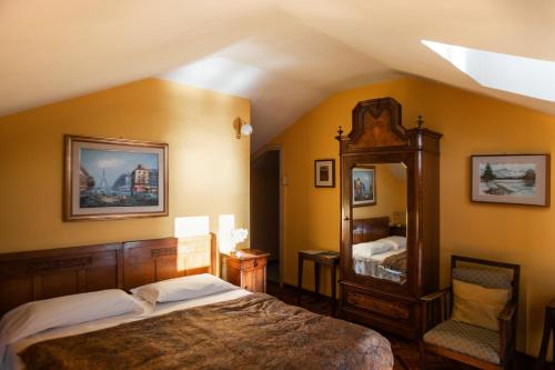 a bedroom with a large bed and a mirror at Hotel Olivedo in Varenna