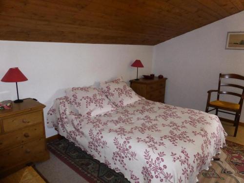 um quarto com uma cama, 2 candeeiros e uma cadeira em Résidence Princesse En Etraz Narcisse - 3 Pièces pour 6 Personnes 294 em Combloux