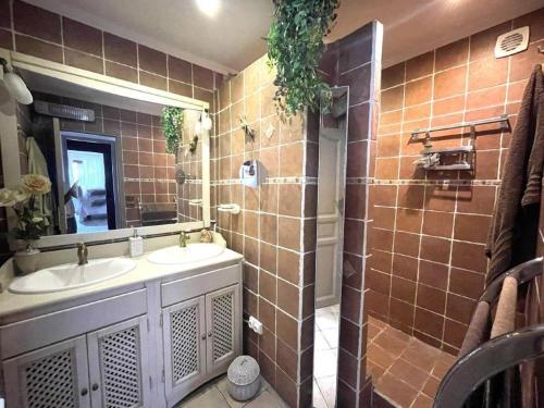 une salle de bain avec deux lavabos et un miroir dans l'établissement Rez de villa avec piscine, à Menton