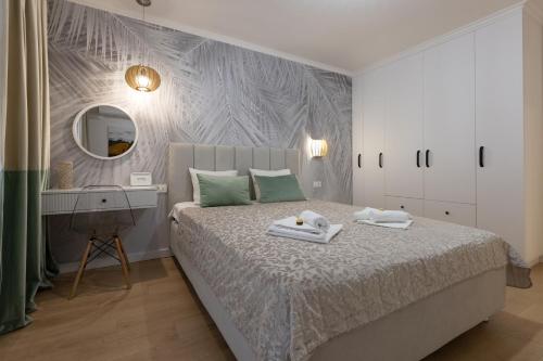 a bedroom with a bed with a desk and a mirror at Imedio Olive Apartment Aviatiei in Bucharest