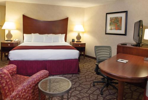 um quarto de hotel com uma cama grande e uma secretária em DoubleTree by Hilton Hotel Oak Ridge - Knoxville em Oak Ridge