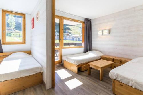 um quarto com duas camas e uma janela em Résidence La Traverse - Studio pour 4 Personnes 924 em La Plagne Tarentaise