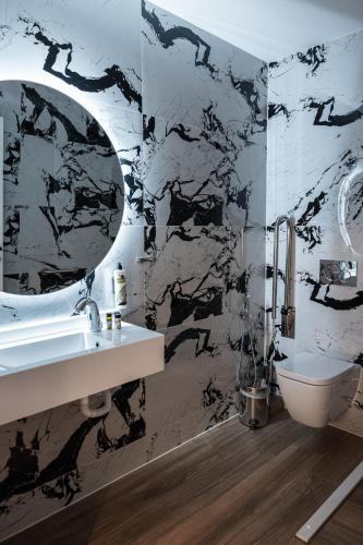 a bathroom with a sink and a mirror at Volos Inn Hotel in Volos