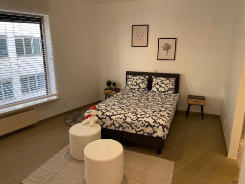 een slaapkamer met een bed en twee witte krukken bij Dreamloft in Antwerpen