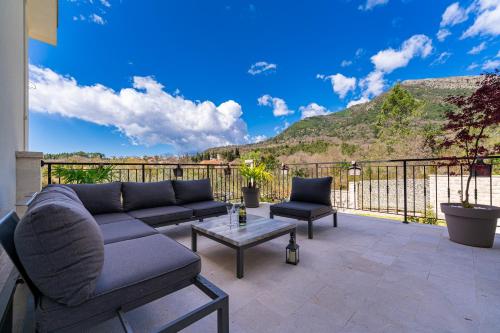 eine Terrasse mit Sofa, Stühlen und einem Tisch in der Unterkunft Majestic Apartment in Tivat