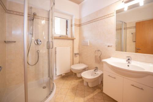 a bathroom with a sink and a shower and a toilet at Leuchtenhof in Caldaro