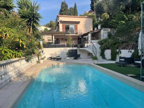 une piscine devant une maison dans l'établissement Rez de villa avec piscine, à Menton