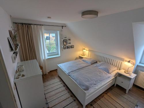 a bedroom with a white bed and two lamps at Deichweg in Zingst