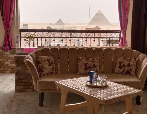 a couch and a table in a room with a view at Giza Pyramids View Apartment in Cairo