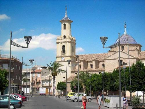 a large building with a clock tower on a street at Hotel COSTAS in Fortuna