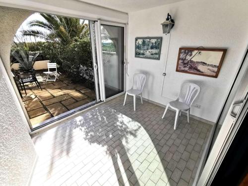 une chambre avec deux chaises et une terrasse couverte avec un patio dans l'établissement Résidence Copacabana - Appartement pour 6 personnes à Port Leucate avec vue sur la mer. Réf: 1COP_103A MAE-4684, à Port-Leucate