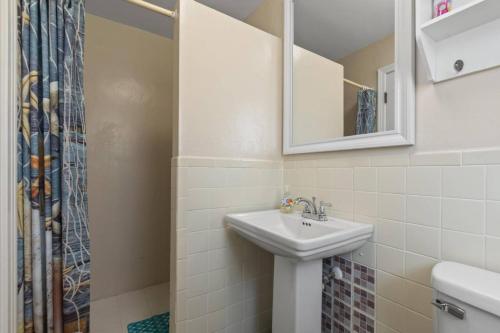 a bathroom with a sink and a mirror and a shower at Quarter Deck Cottage on Flagler Beach in Flagler Beach