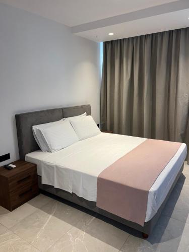 una camera da letto con un grande letto con lenzuola bianche di JOHANNES LUXURY VILLAS a Kolímbia