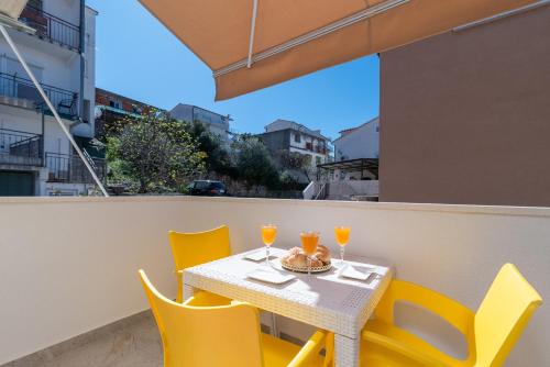 a table and chairs with drinks on a balcony at Aldino Rooms in Trogir