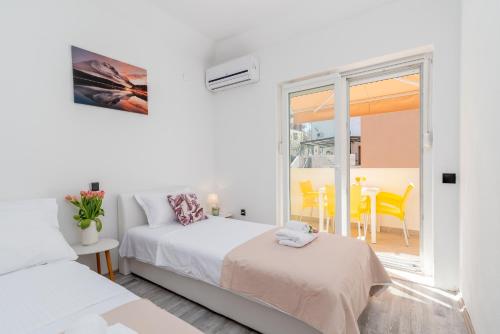 a bedroom with two beds and a balcony at Aldino Rooms in Trogir