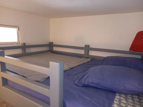 une chambre avec un lit superposé et une fenêtre dans l'établissement Bandol, T3, les pieds dans l'eau, presqu'île du Capelan, à Bandol